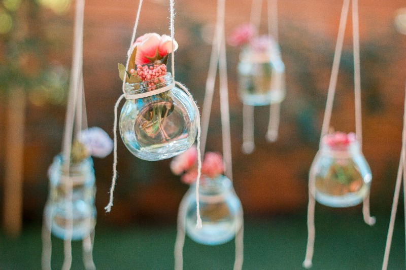 Decoration made of hanging glass jars with flowers. Soft focus
