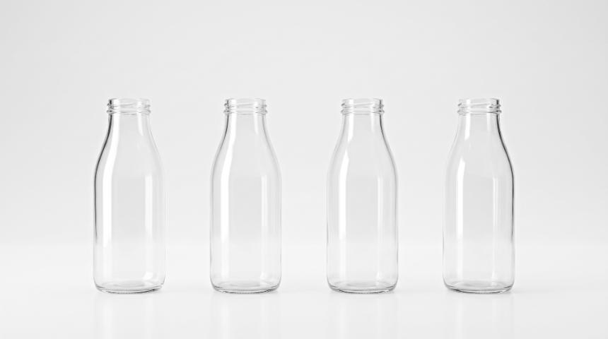 empty glass milk bottles on a plain industrial surface